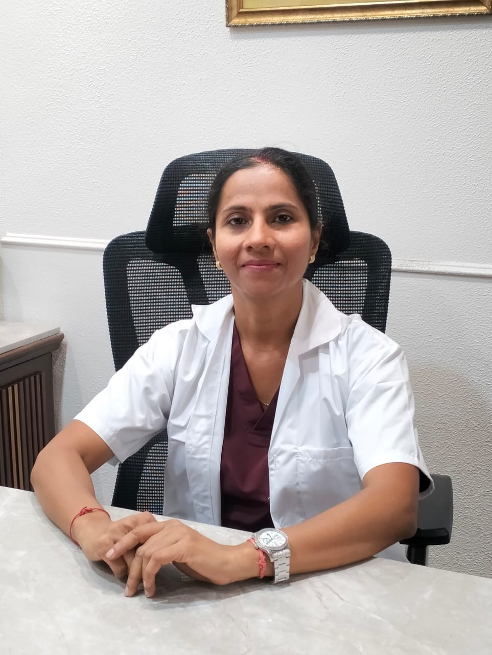 Dr. Chetna, a spine specialist, sits at her desk ready to consult with patients.